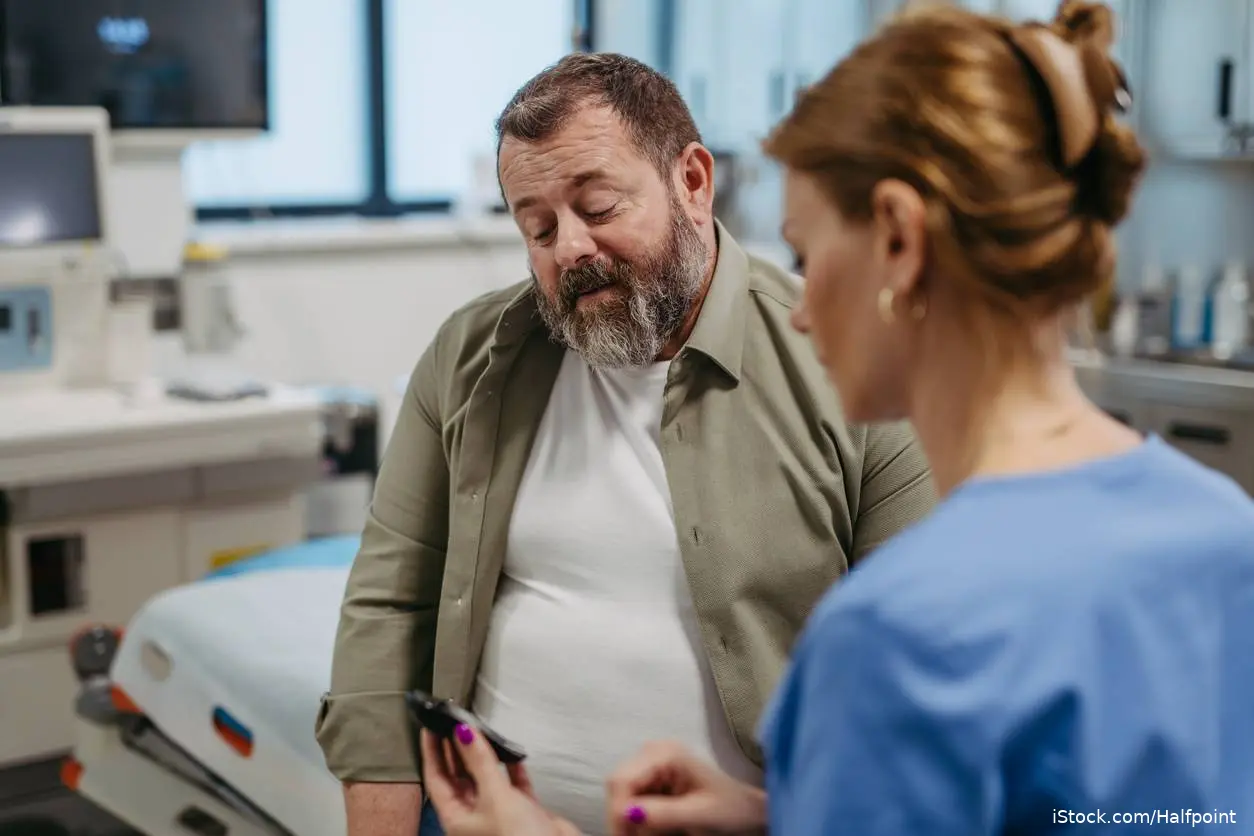 Middle age over weight white male with diabetes with female doctor iStock-1796946357