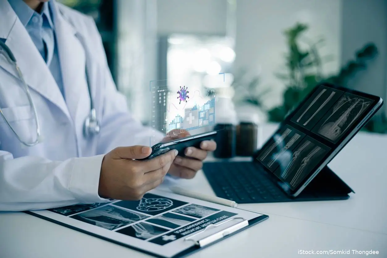 Doctor using Ai at desk and on phone iStock-1643688727