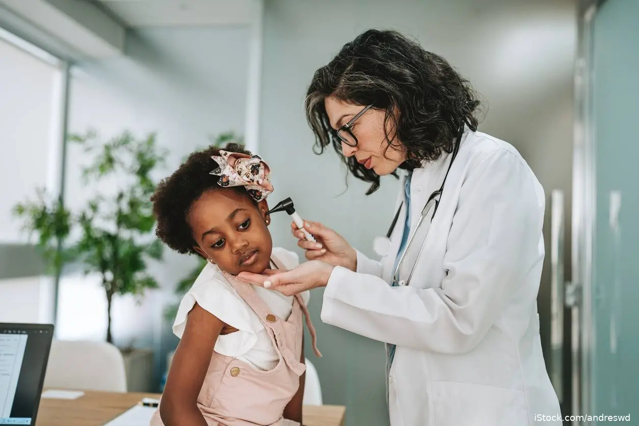 Doctor looking at child's ear