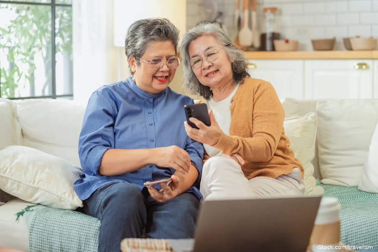 Two elderly Asian women use AI to look up health conditions