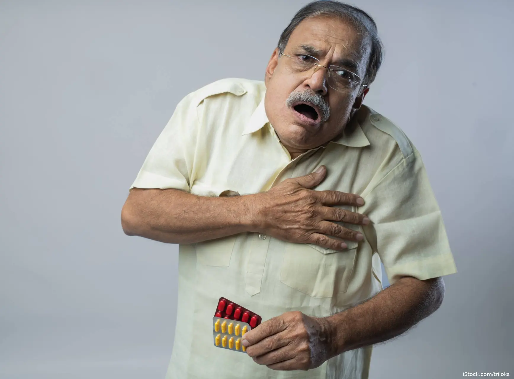 man holding chest indicating heart attack