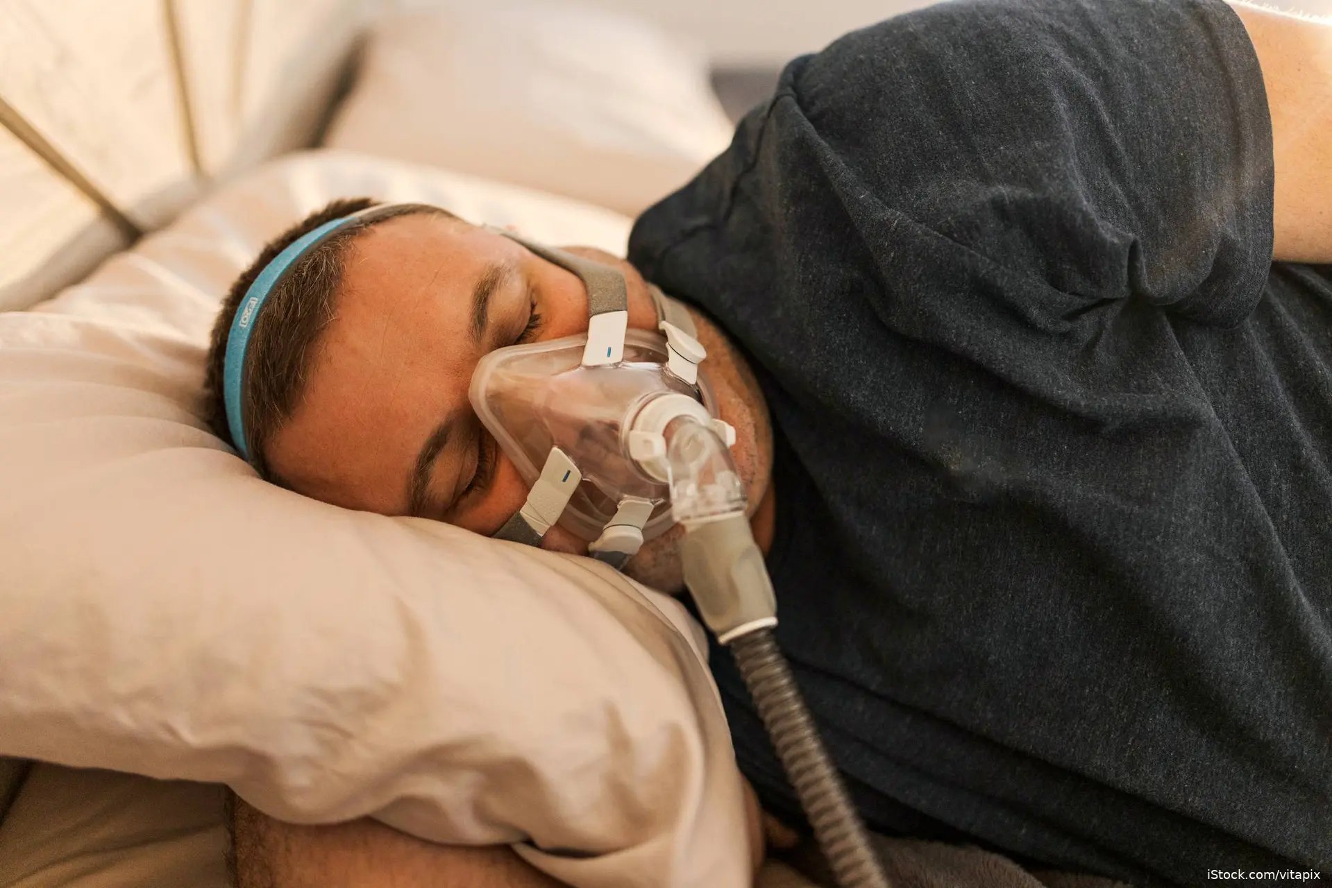 man sleeping with sleep apnea mask