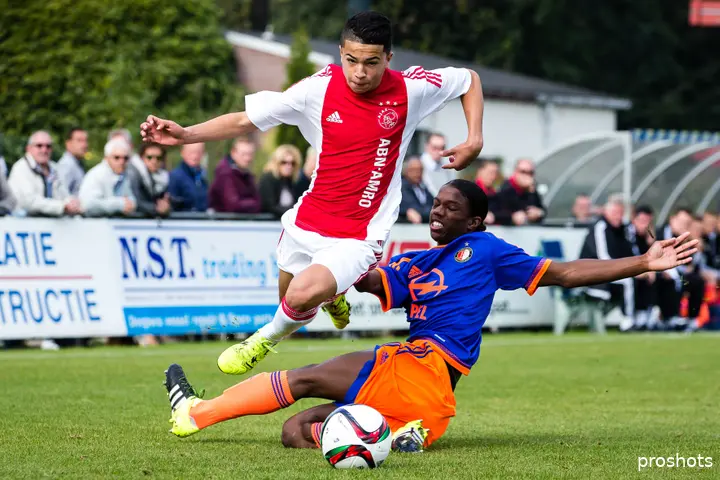 Rayan El Azrak in een duel met Tyrell Malacia.