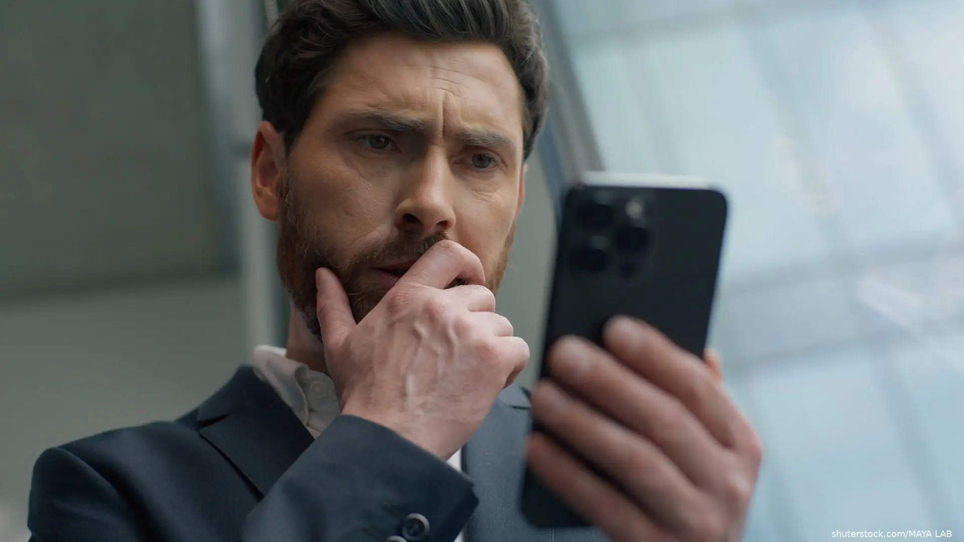 nervous man looking at smartphone