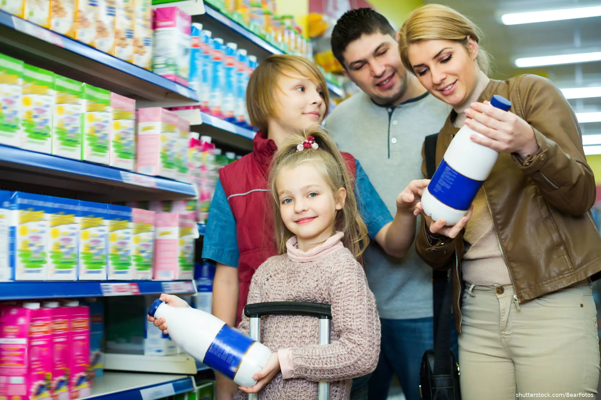 Family of four buying pasteurized milk in market