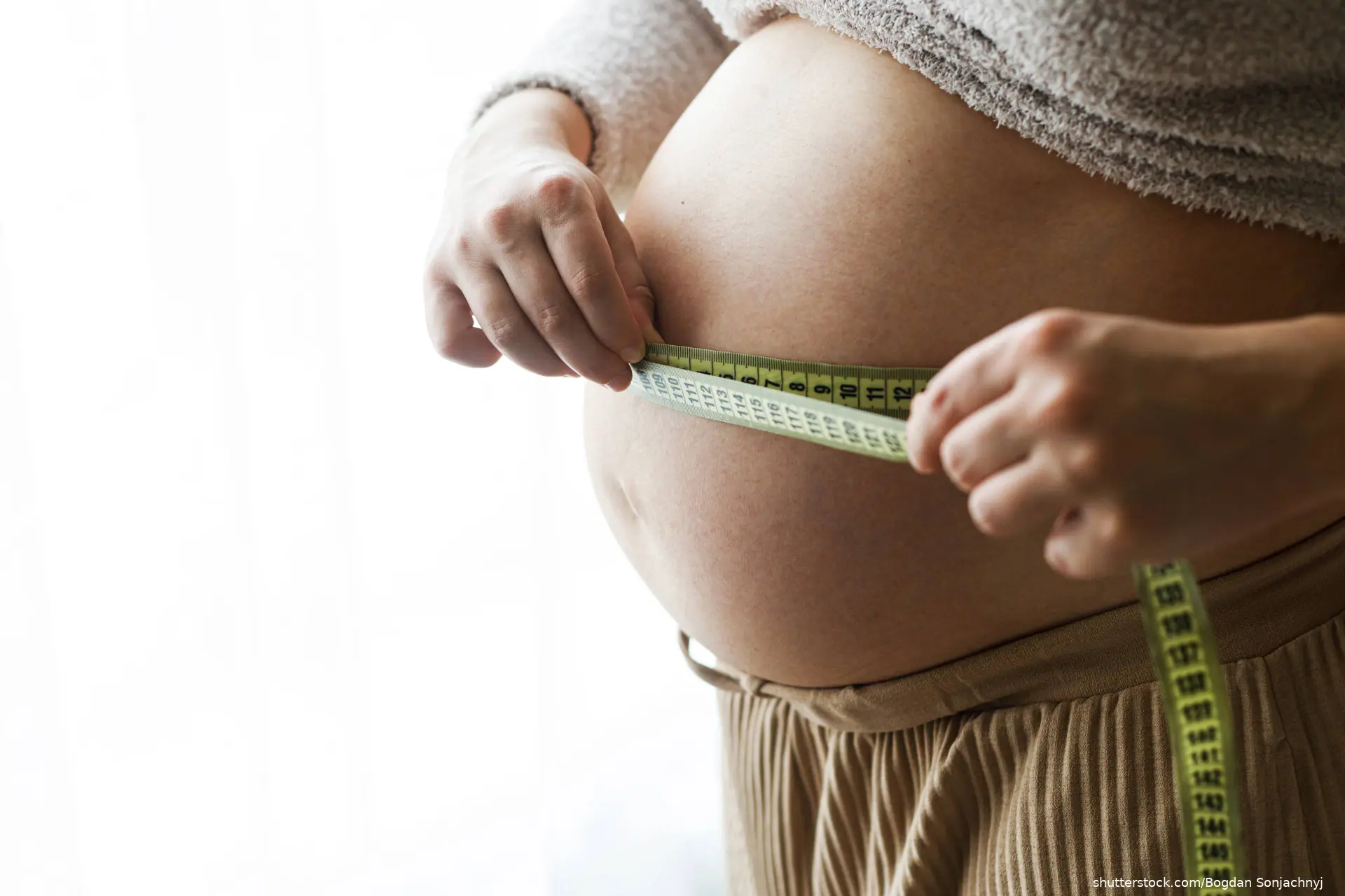 pregnant woman measuring stomach