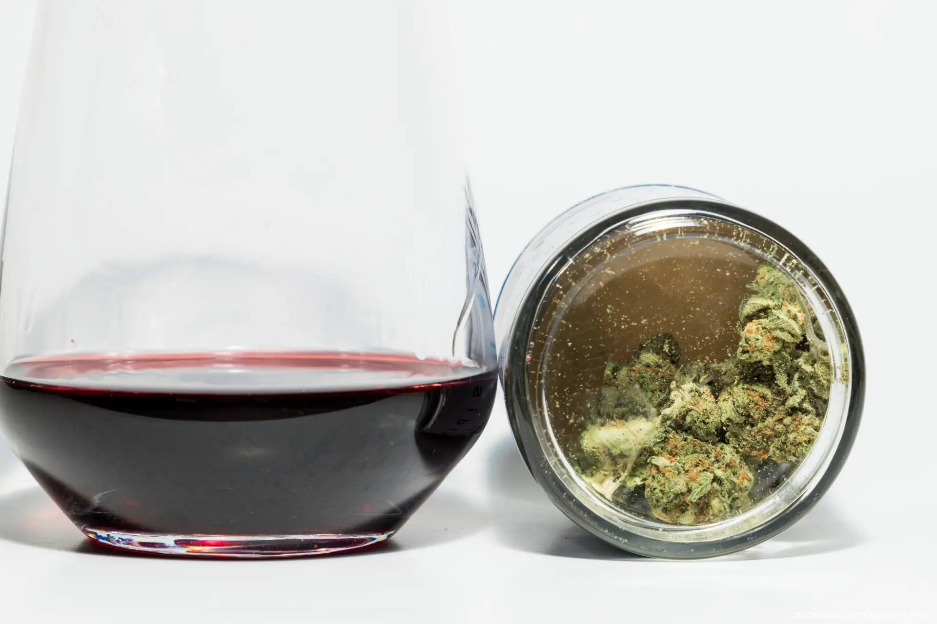 glass of wine next to jar of cannabis