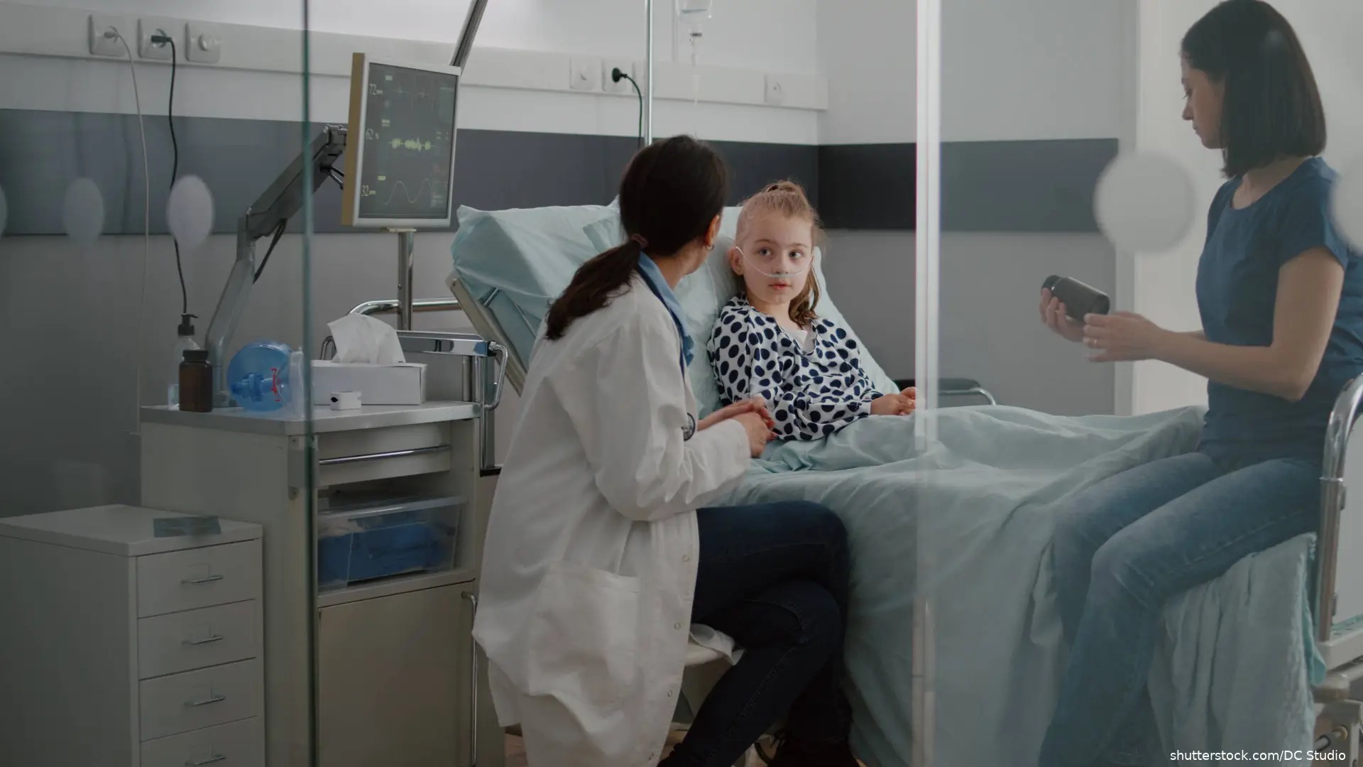 child in hospital bed  talking with mother and doctor