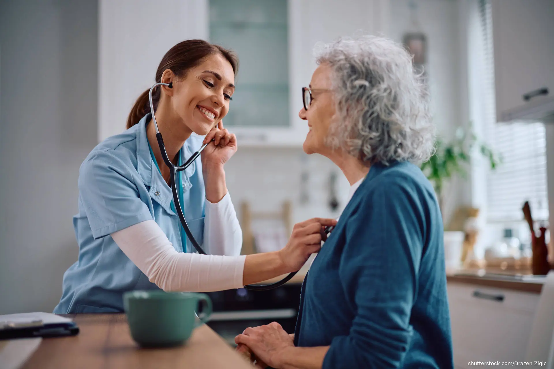 doctor listening to heart of senior woman during a house call