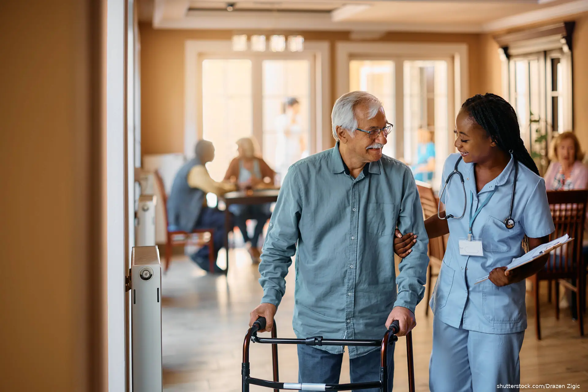 man using walker be helped by nurse in nursing home