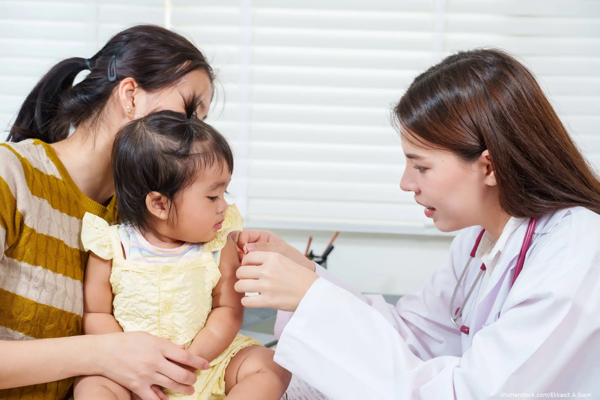 toddler on mother's lap getting a vaccine