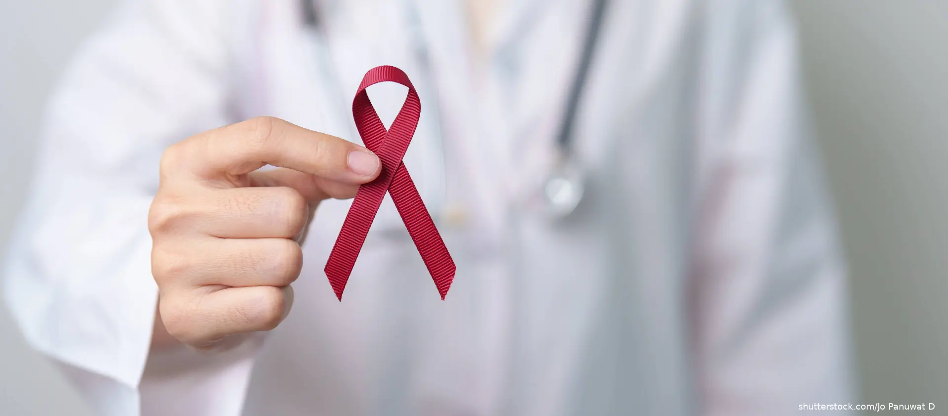 doctor holding a burgundy ribbon