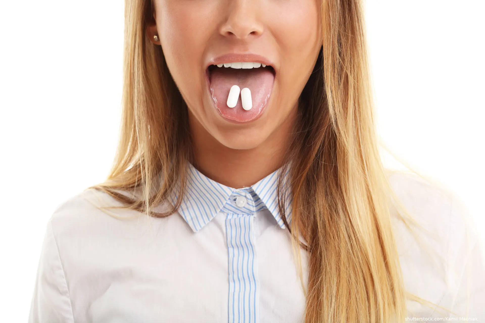 Closeup of woman with two pills in her mouth