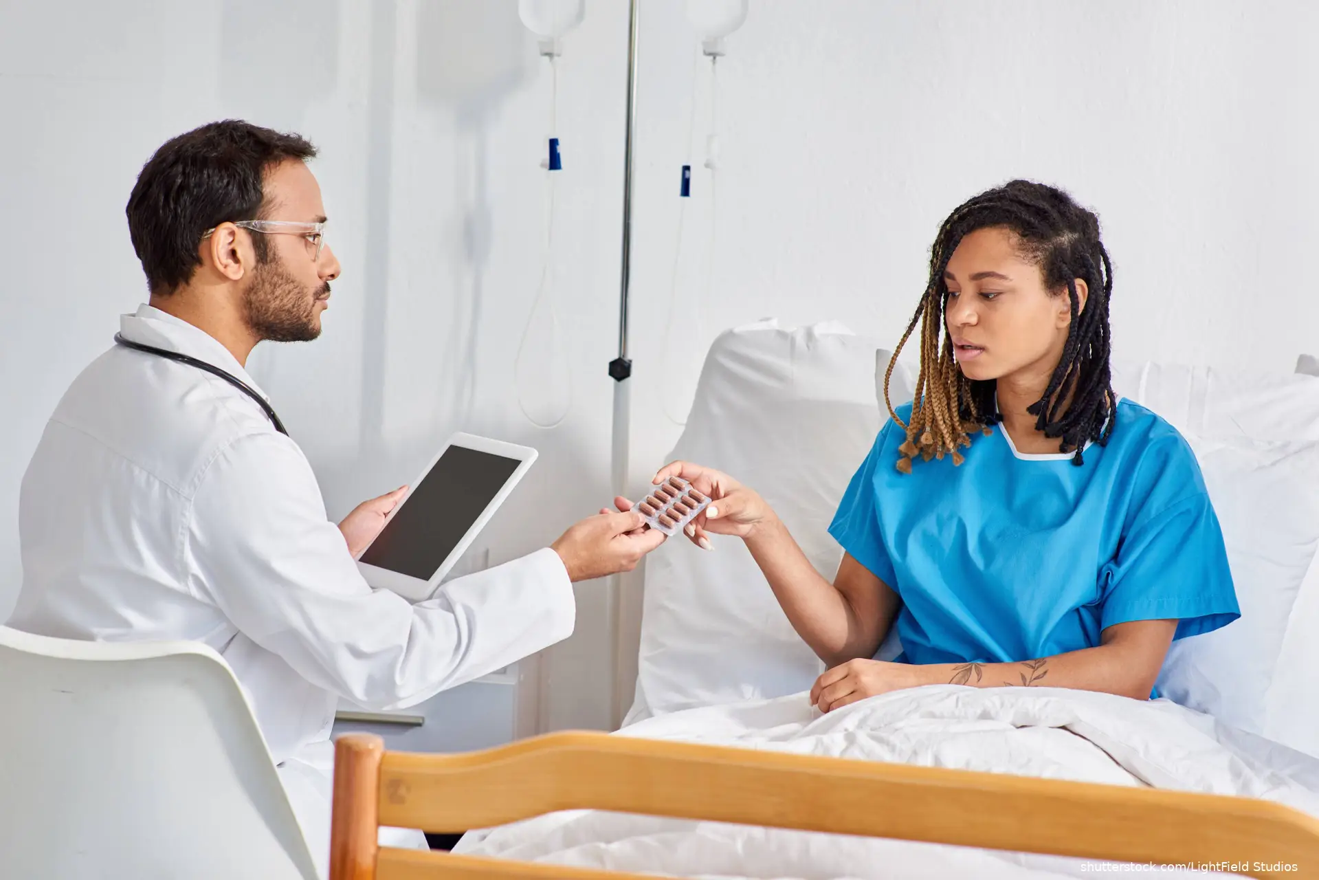 doctor talking to patient holding ipad shutterstock_2393487651