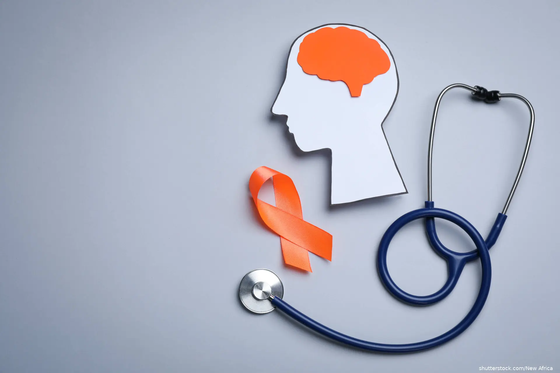 MS awareness orange ribbon, stethoscope and cutout of a head and orange brain shutterstock_2055781127
