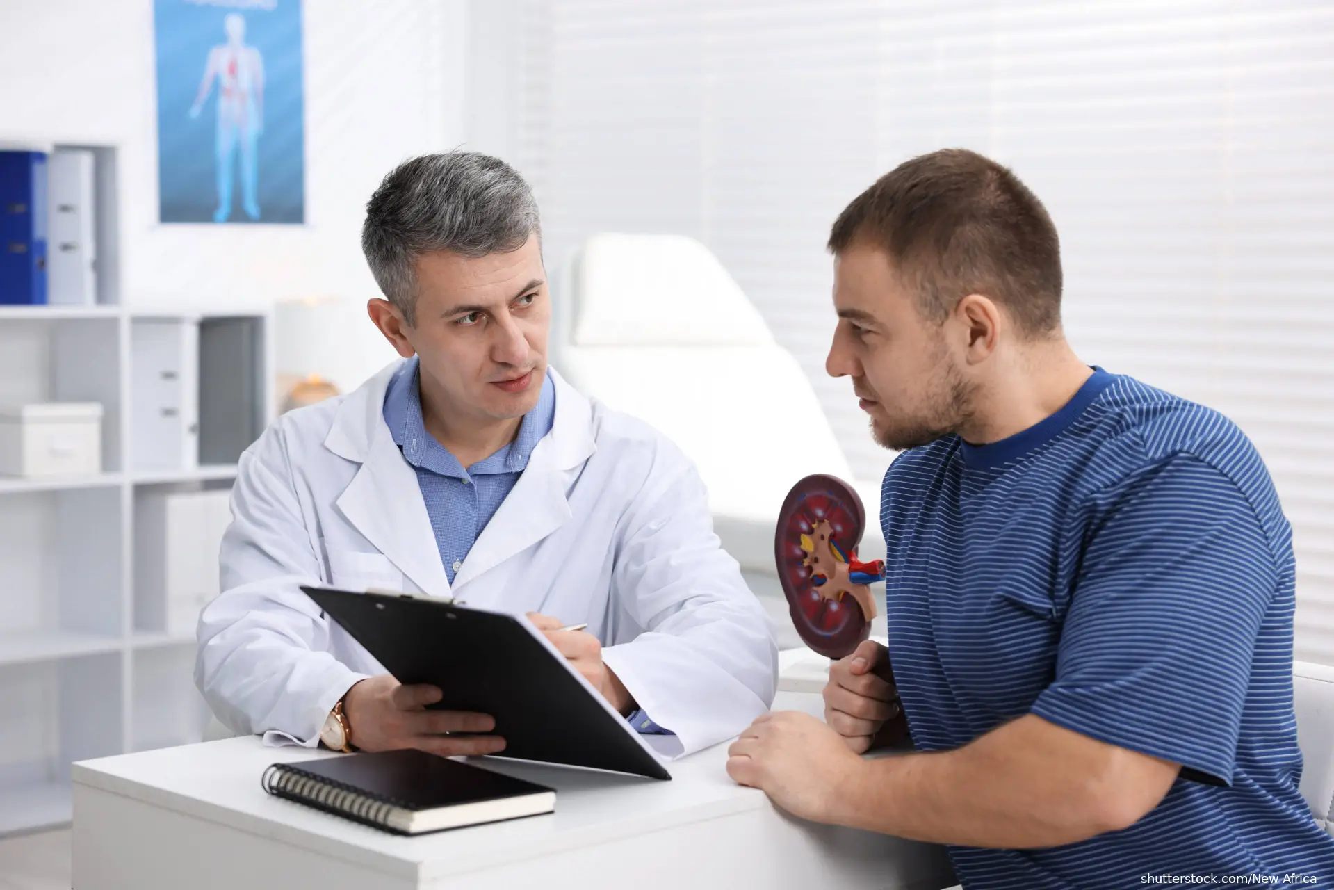 Urologist showing clipboard to patient at white desk in clinic