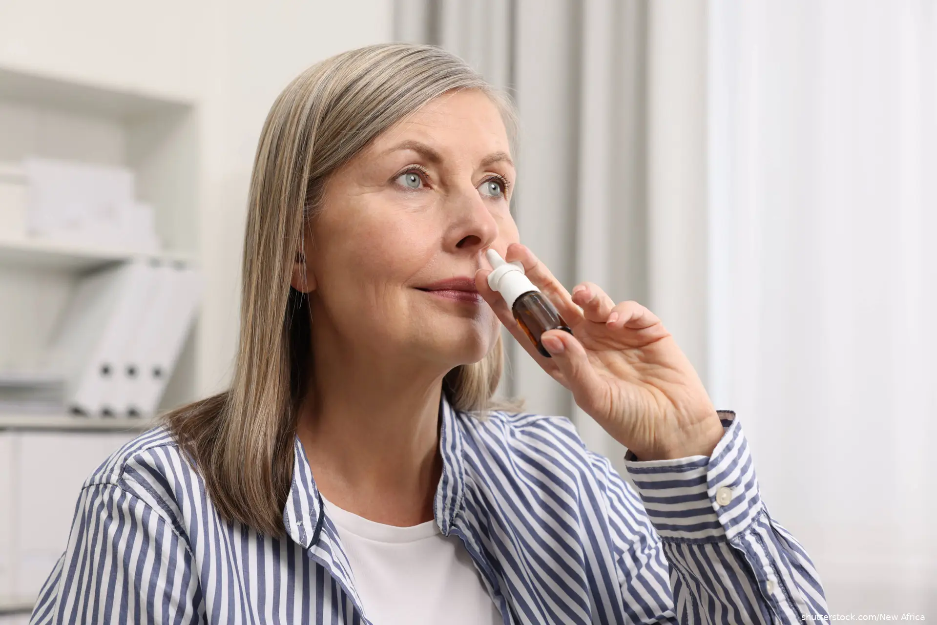 Woman using nasal spray