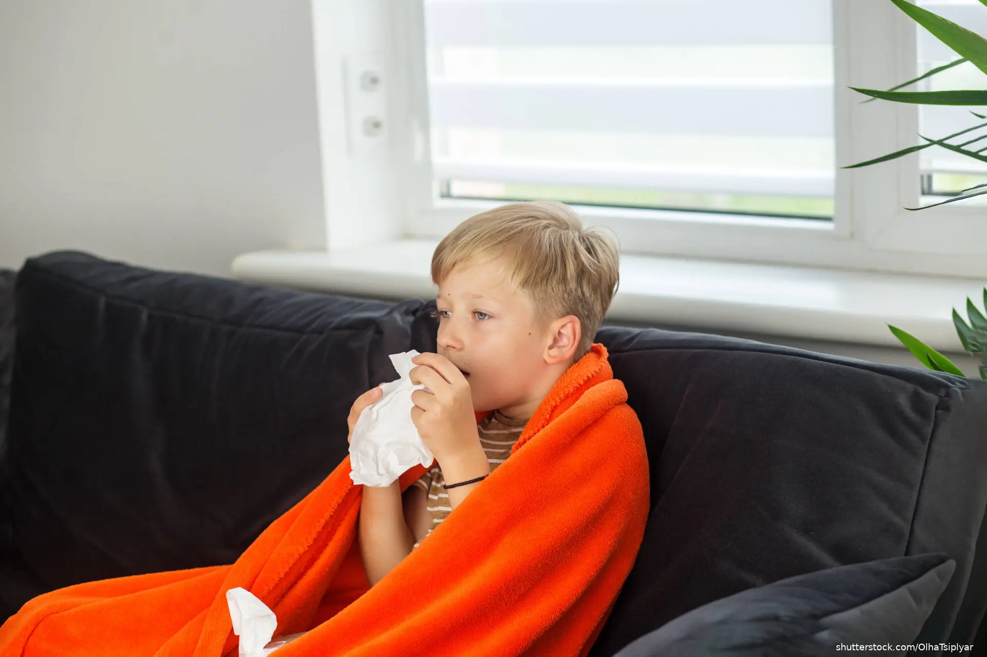 Young boy with blanket coughing