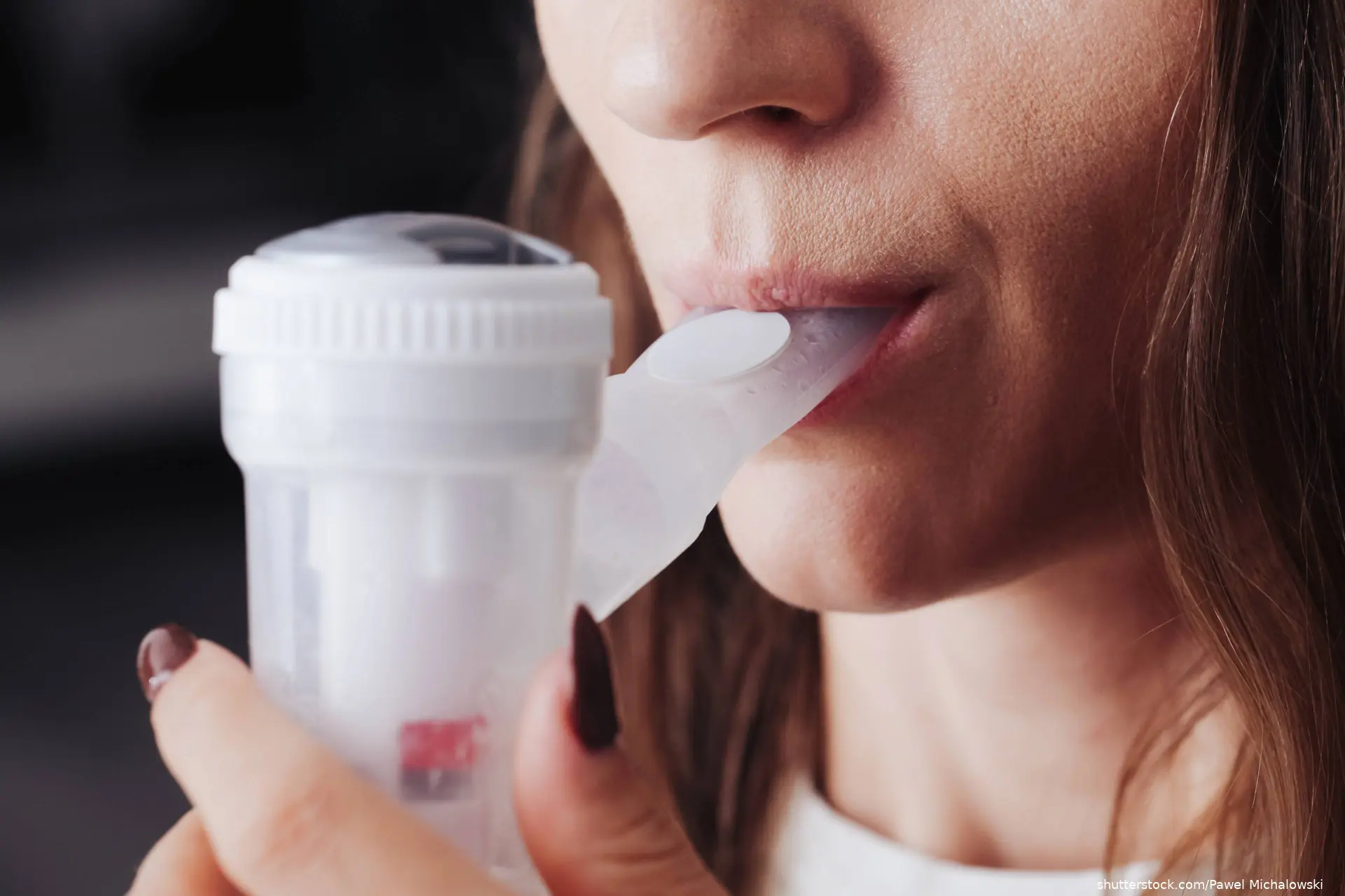 Woman with inhaler in her mouth
