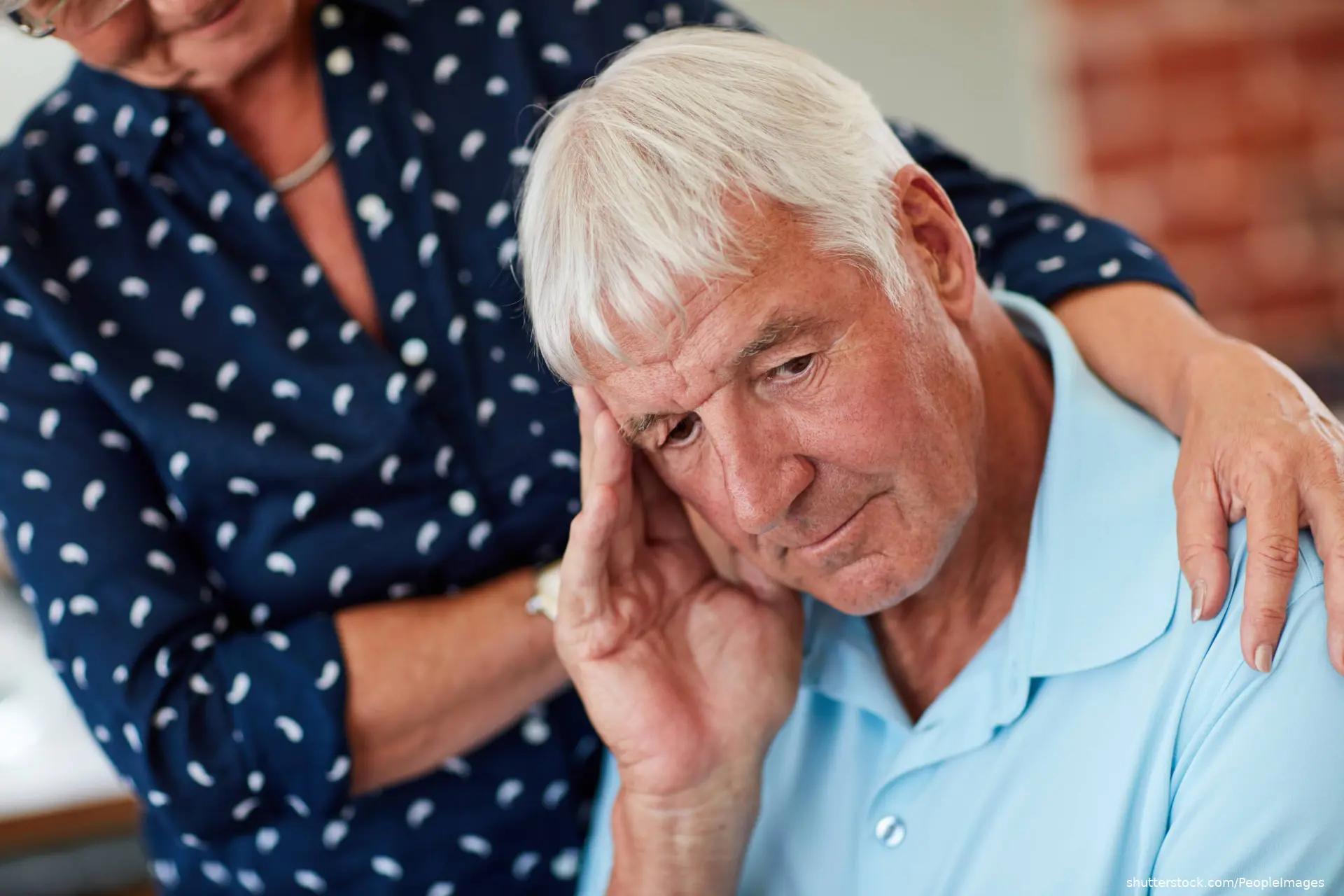 elderly woman comforting elderly man
