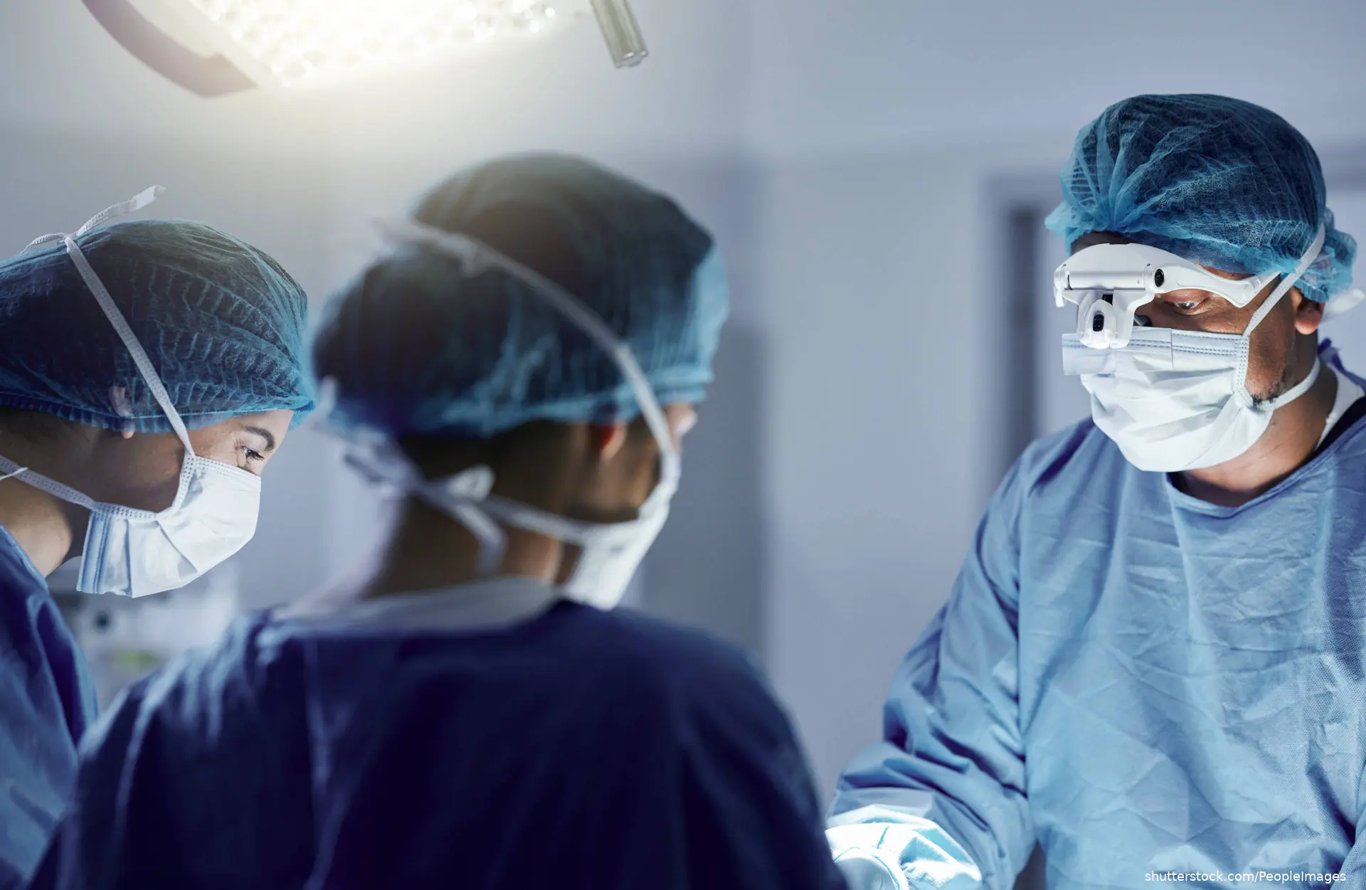 surgical team performing surgery in operating room shutterstock_2374428523