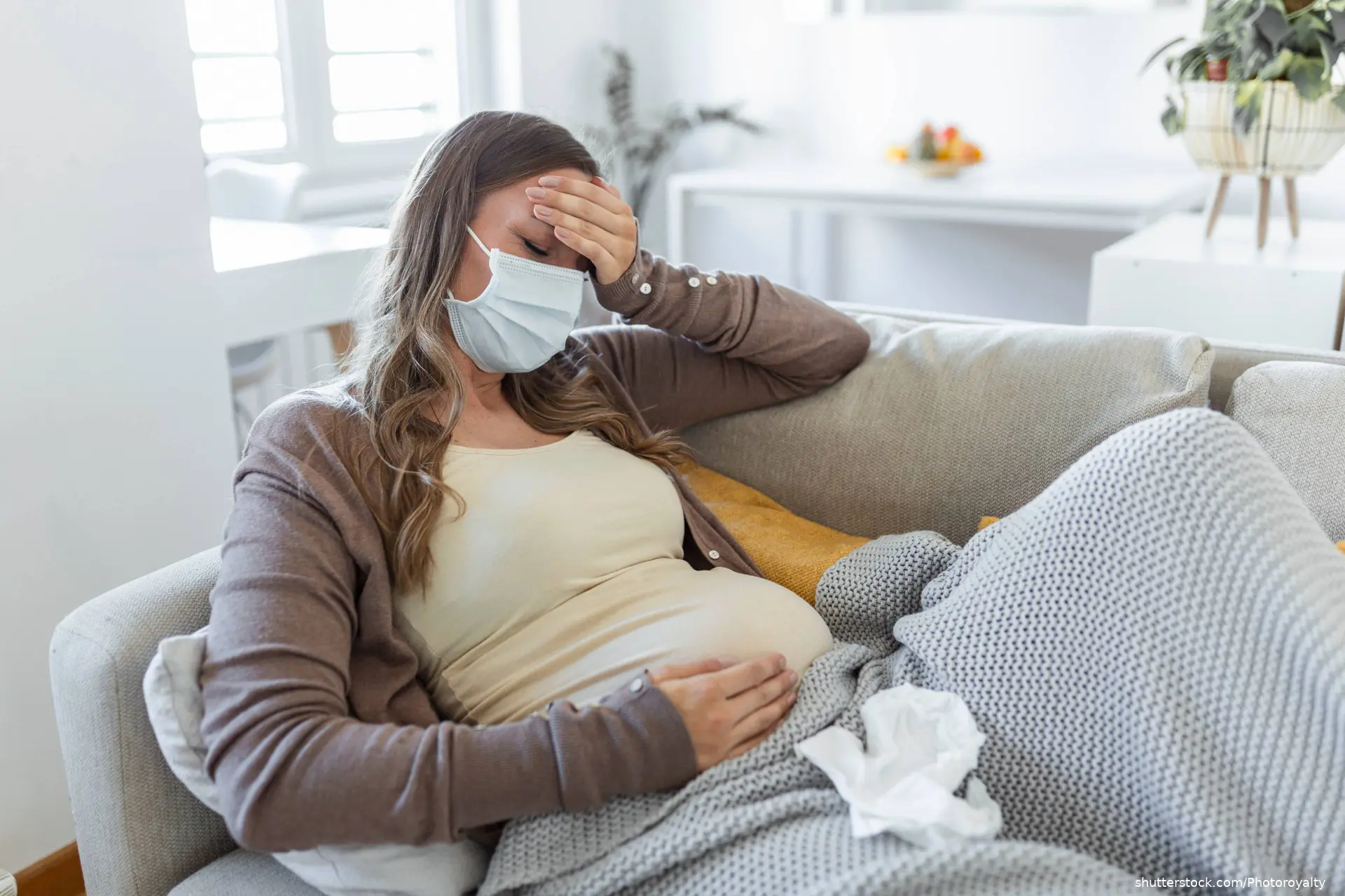 pregnant woman on couch with mask