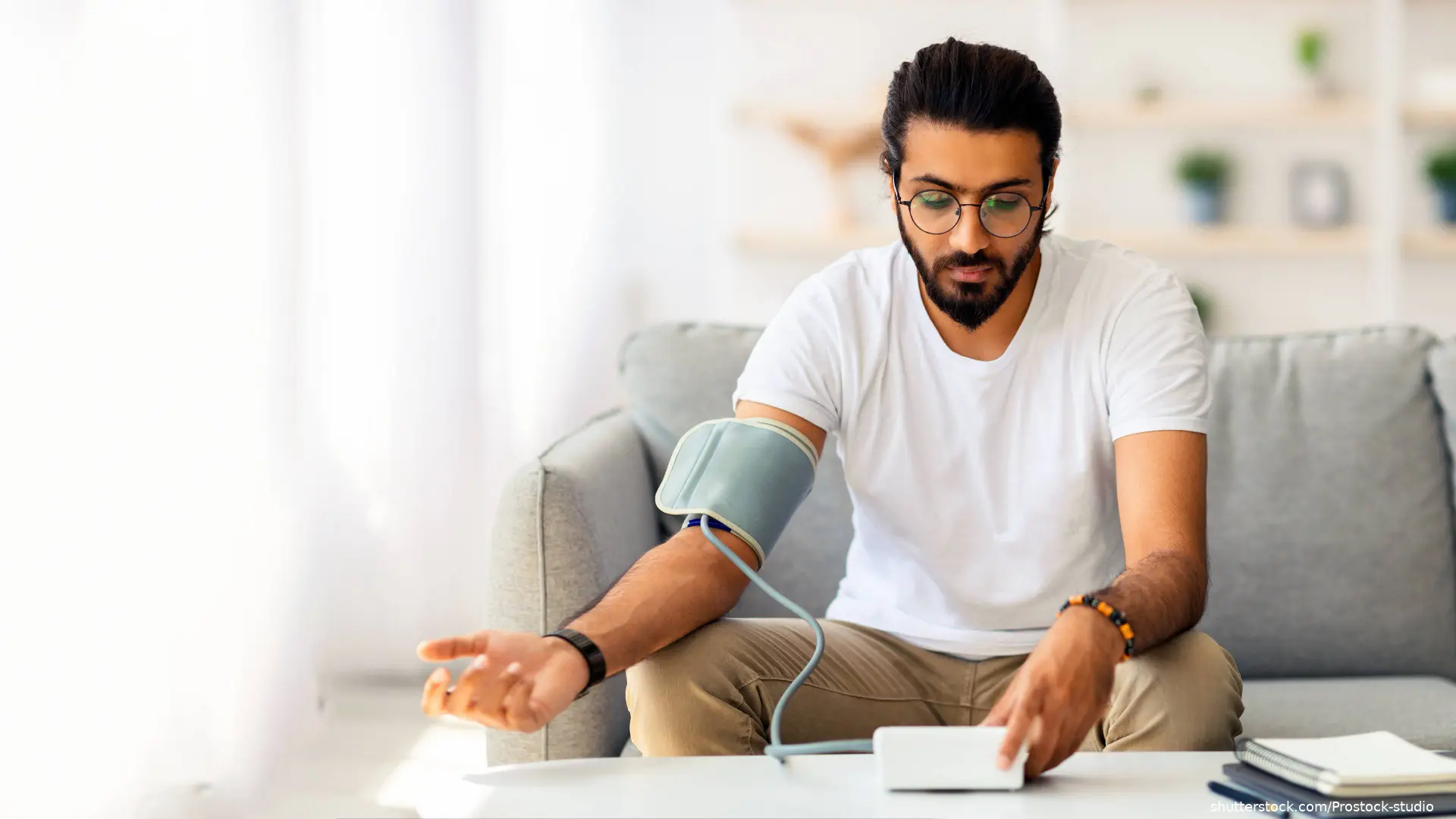 man using a blood pressure monitor