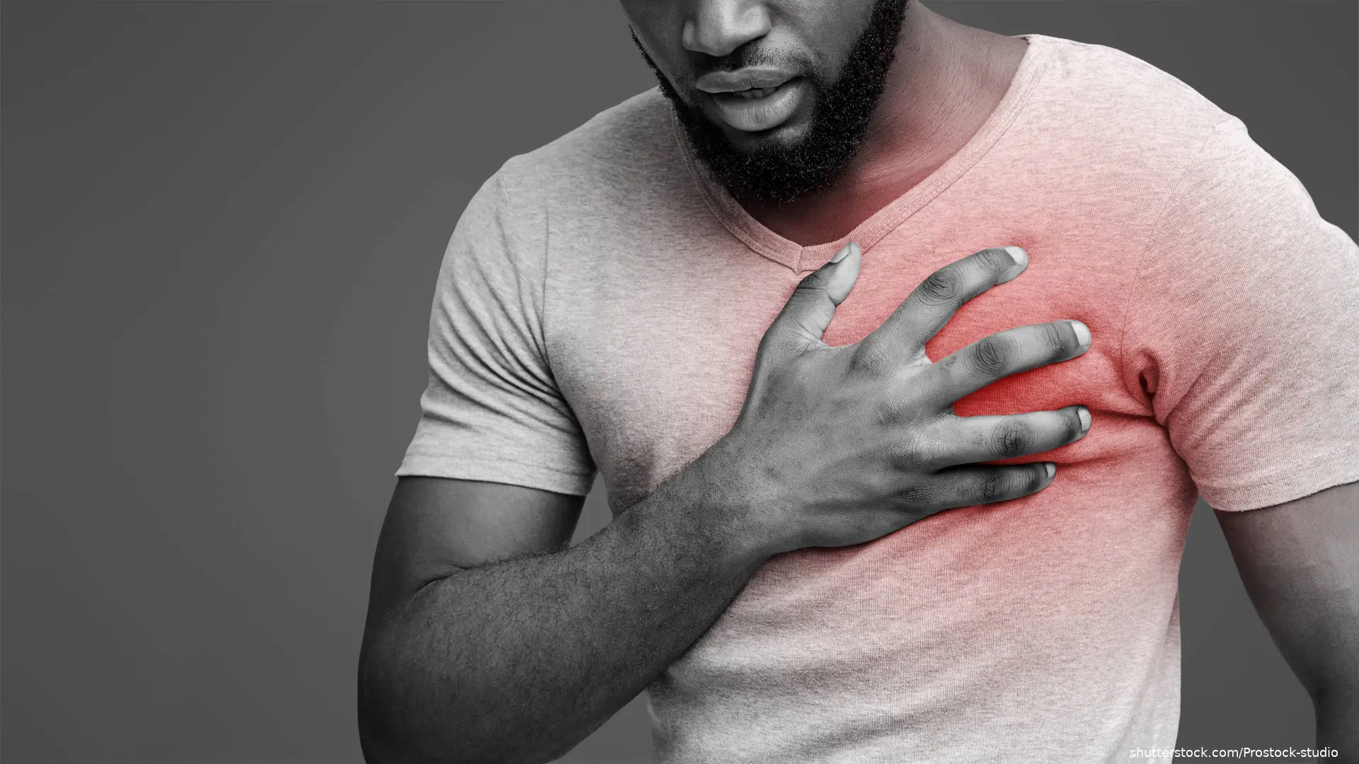 Man holding hand over left side of chest