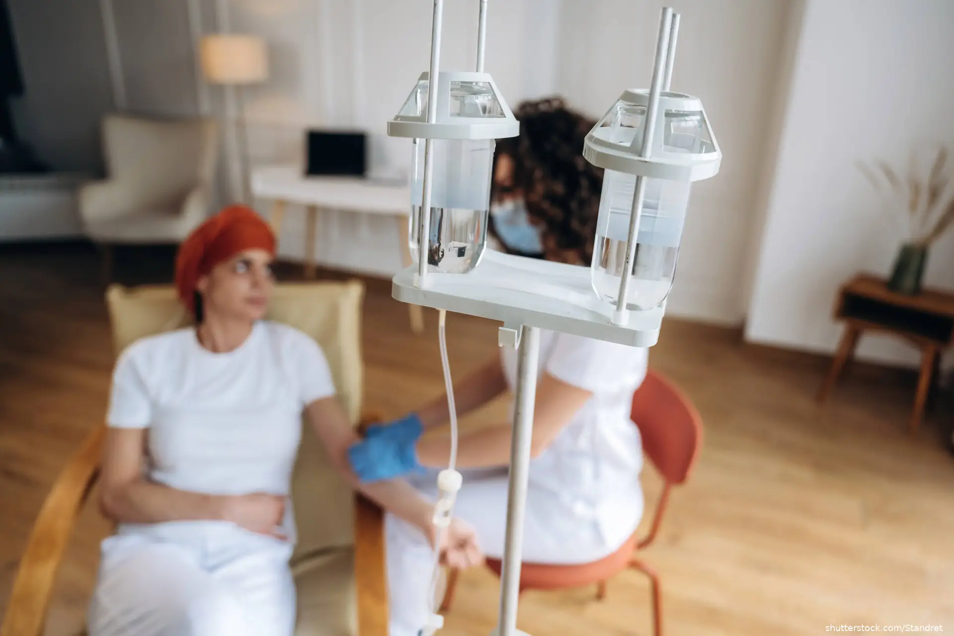 Female patient undergoing chemotherapy sits in a chair while shutterstock_2769648063