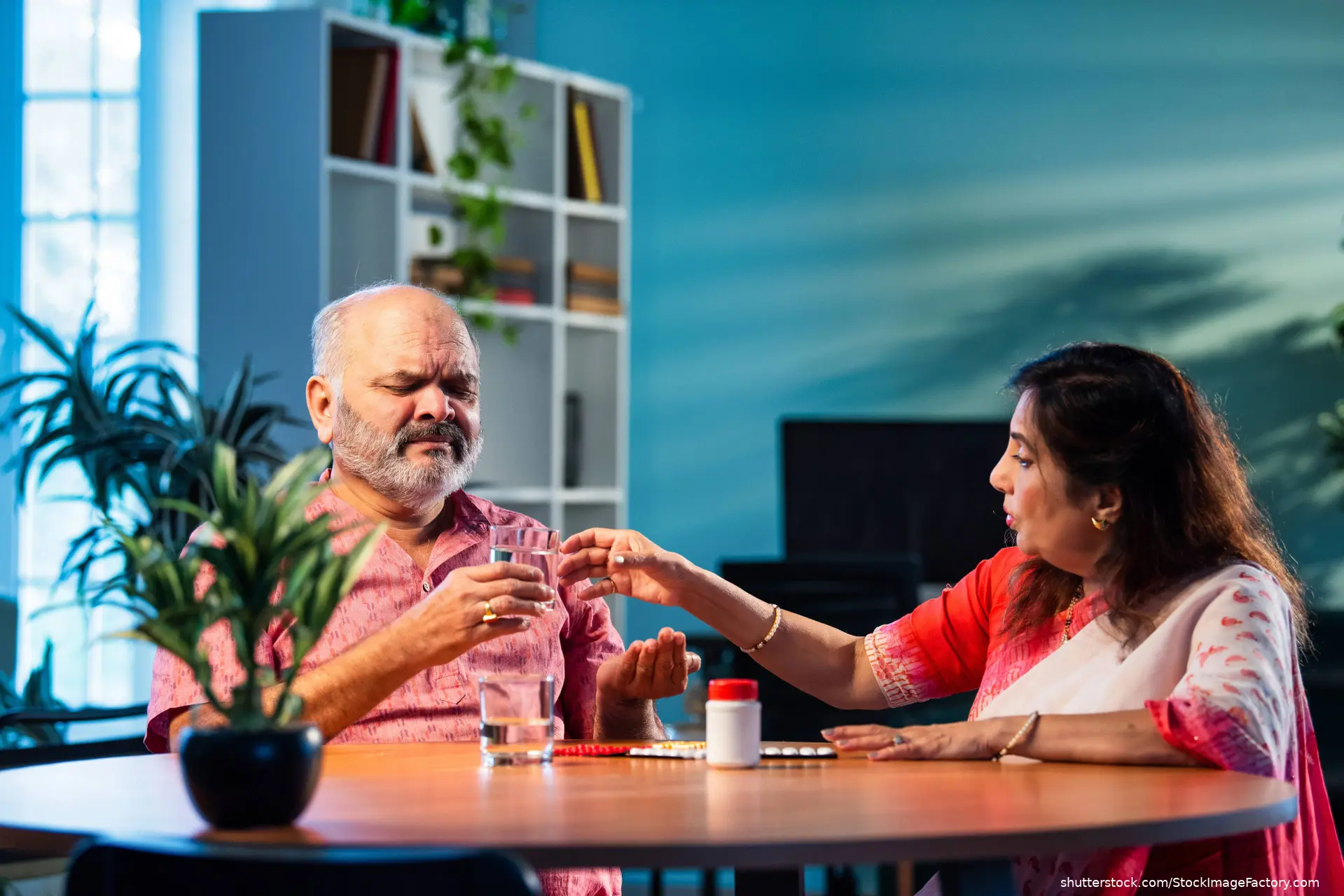 woman helping man take medication