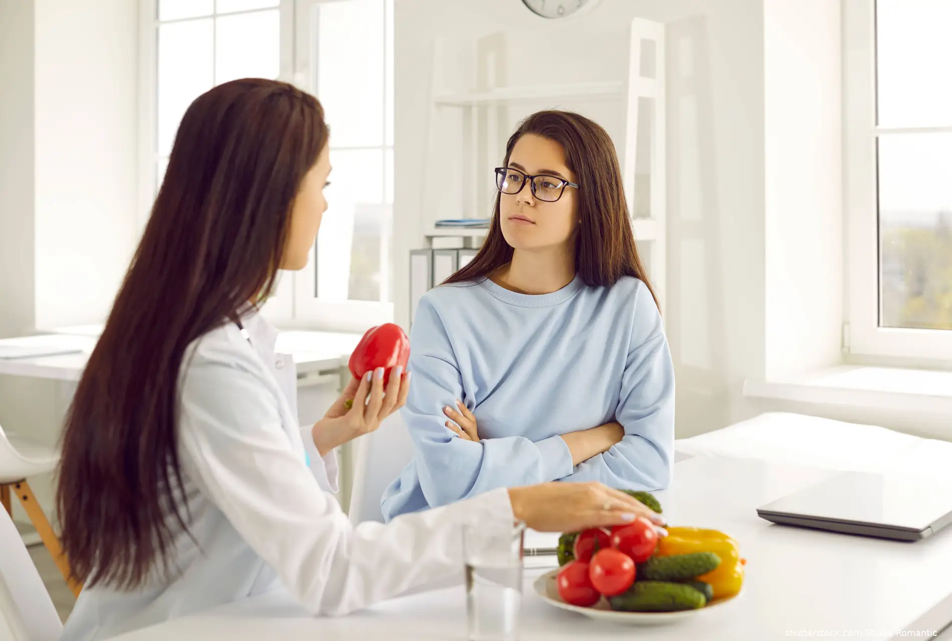 nutritionist teaches young woman to eat healthy food