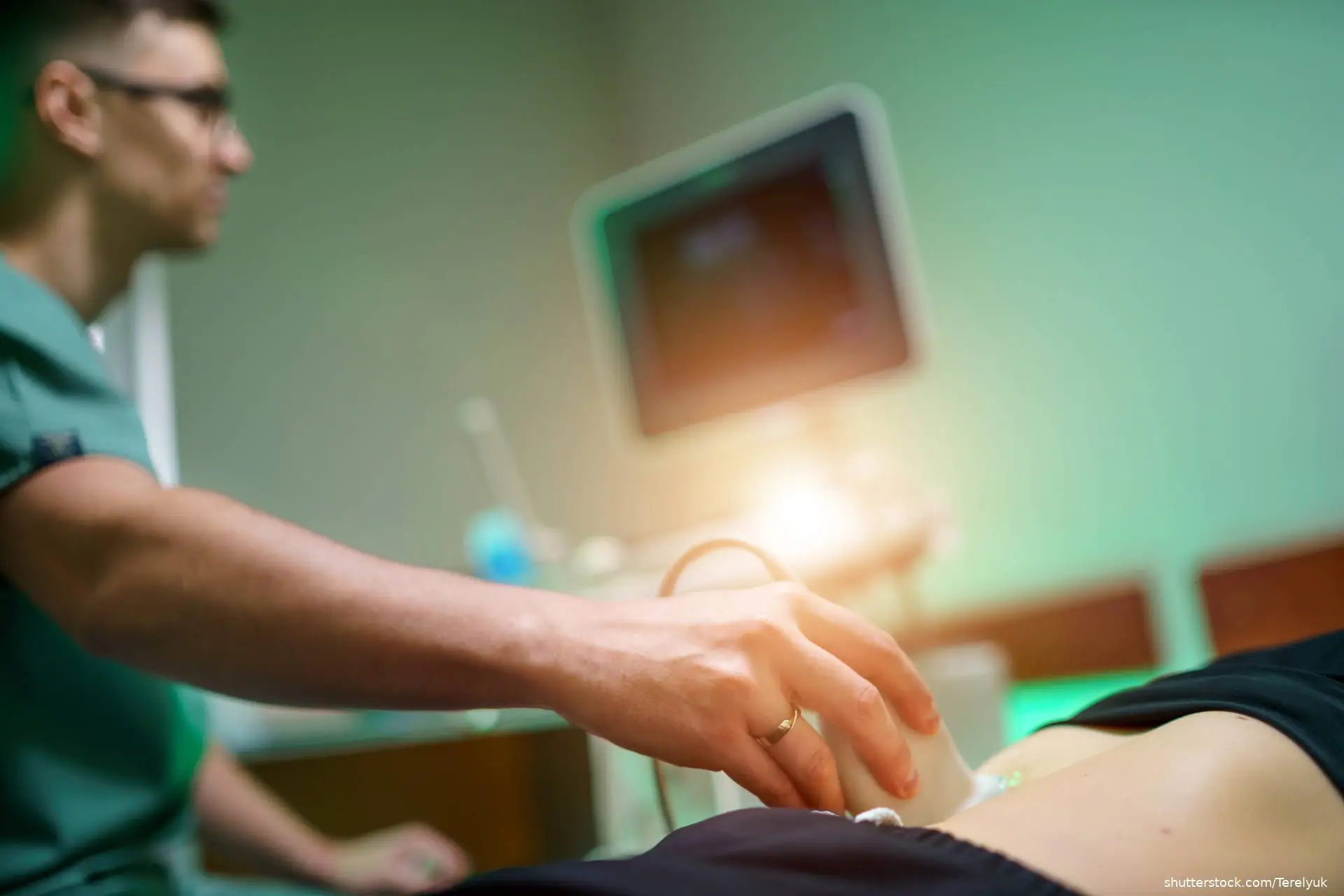 Doctor performing abdominal ultrasound on patient