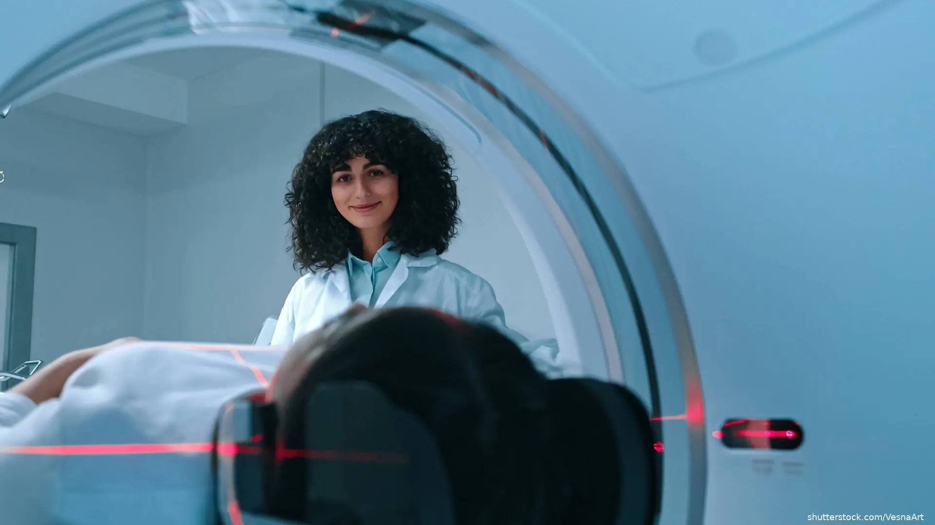 Technician preparing patient for brain MRI