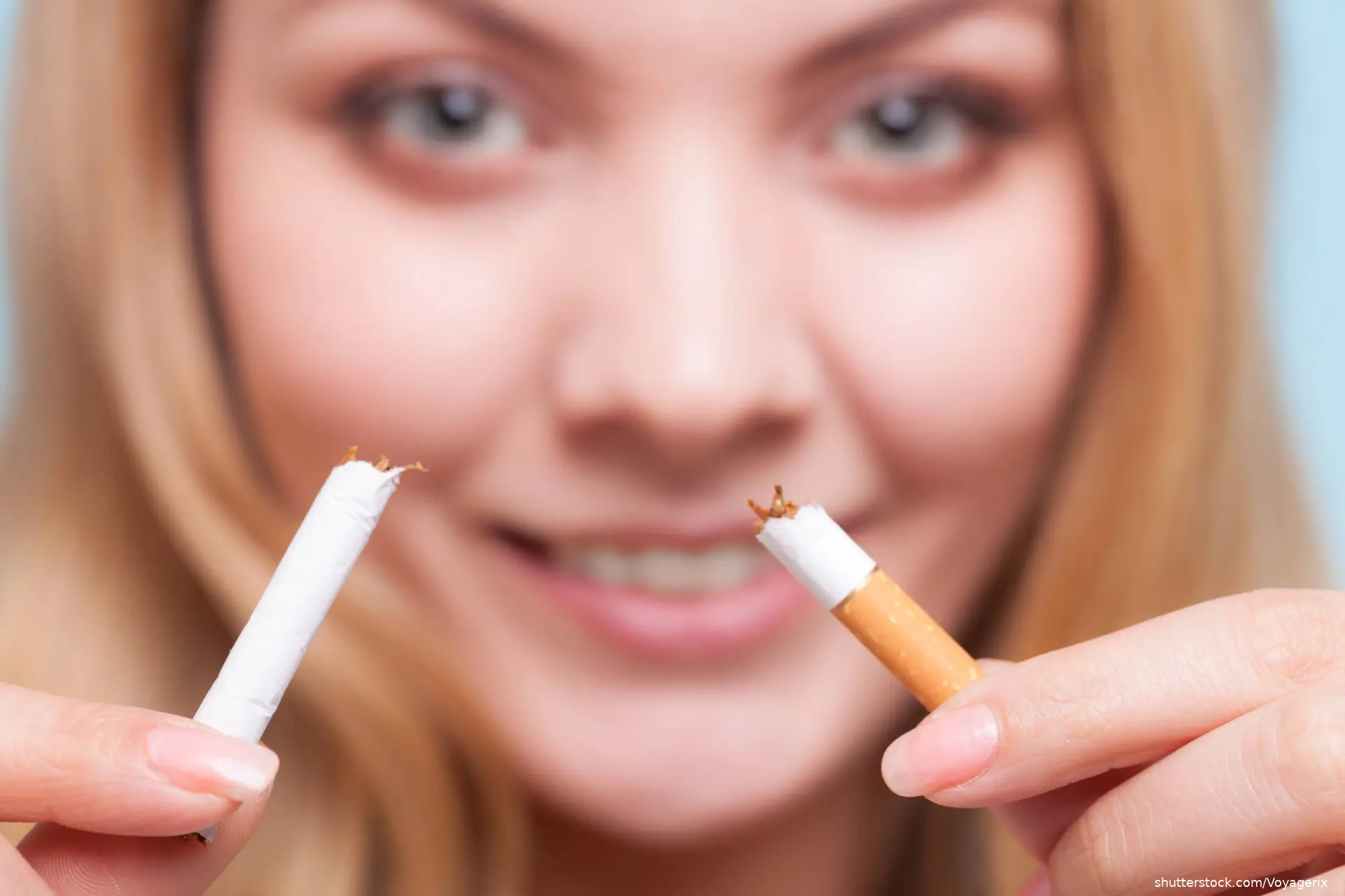 woman smiling holding broken cigarette