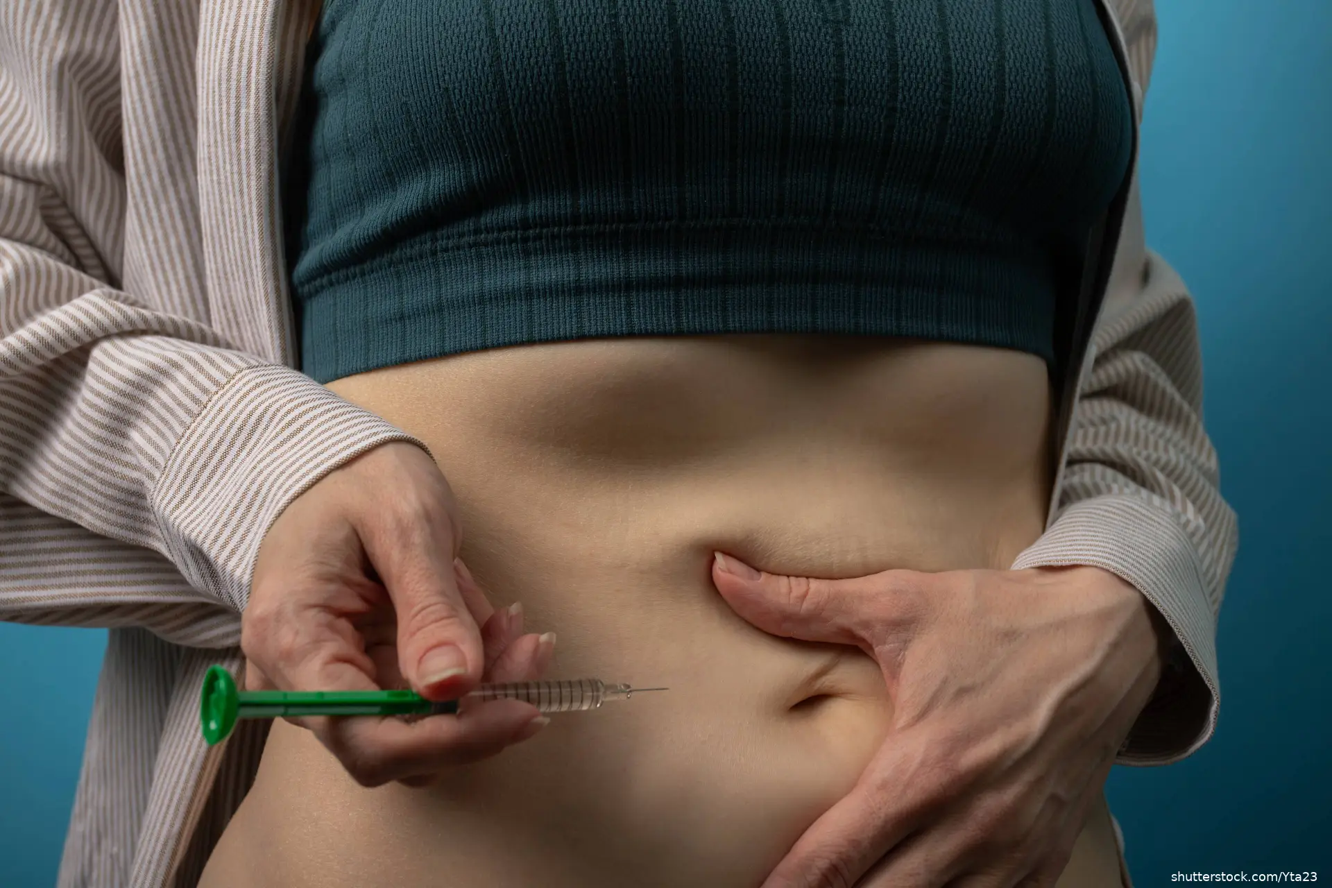 woman injecting medication in her abdomen