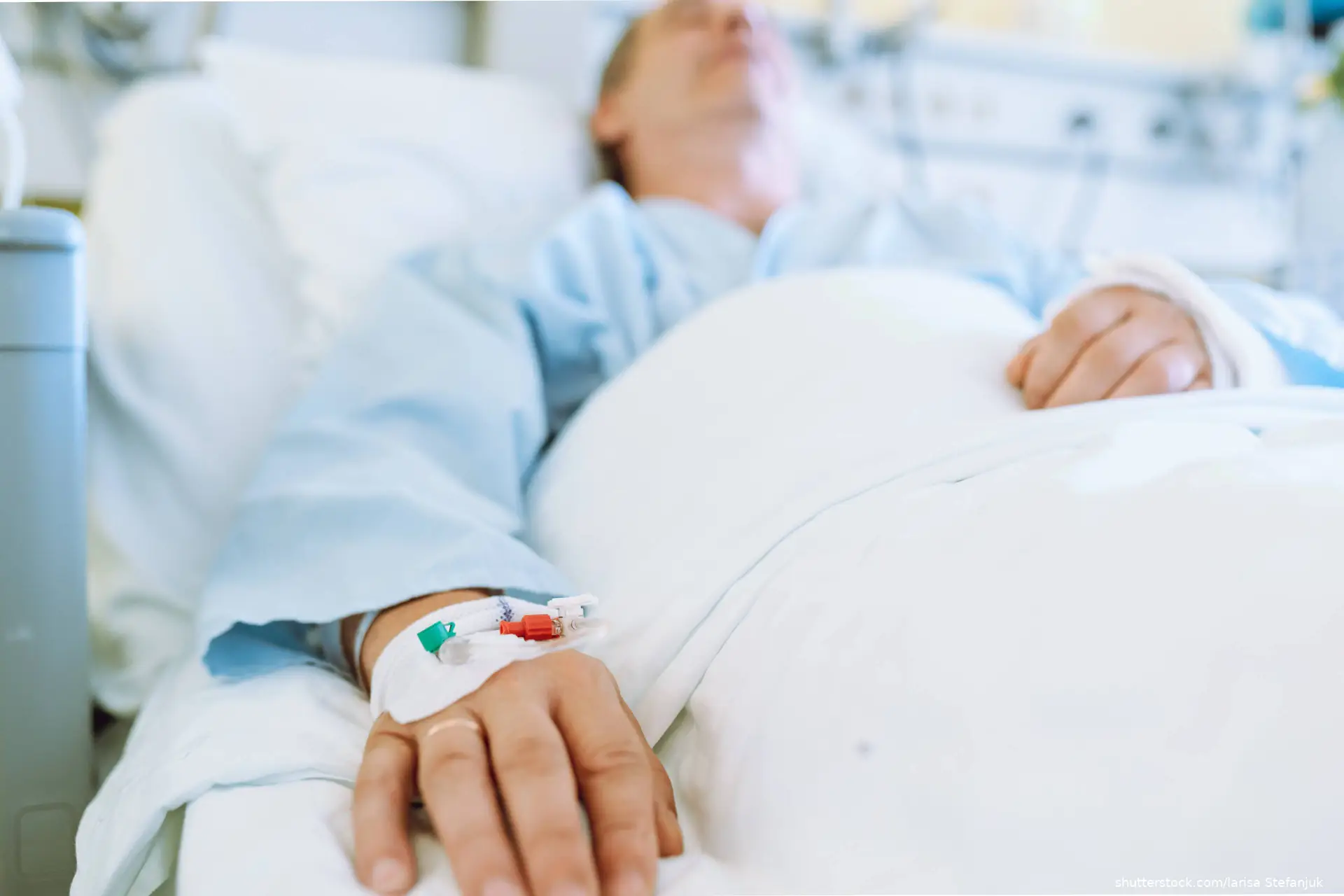 man in hospital bed getting an IV