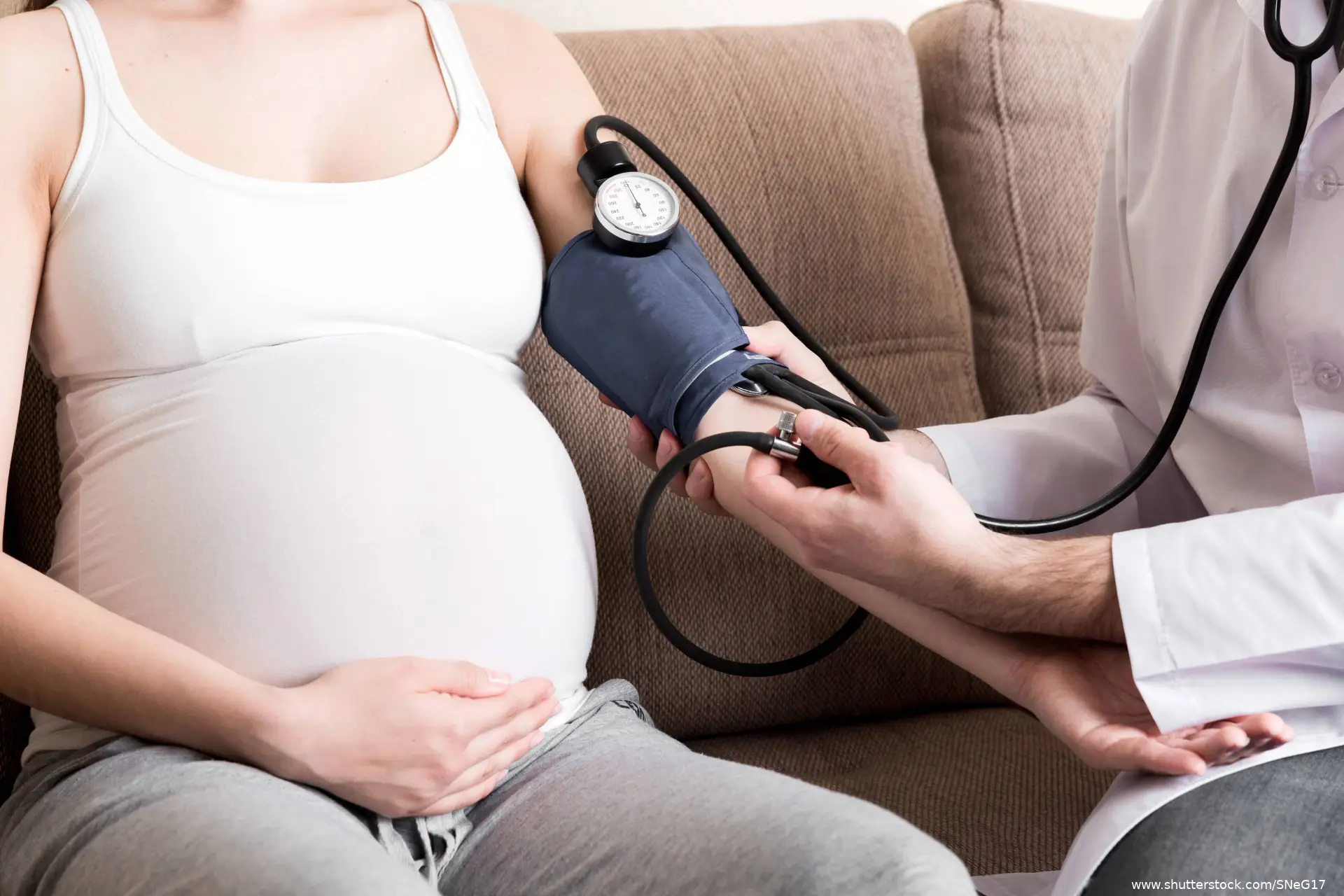 doctor is taking a pregnant woman's blood pressure