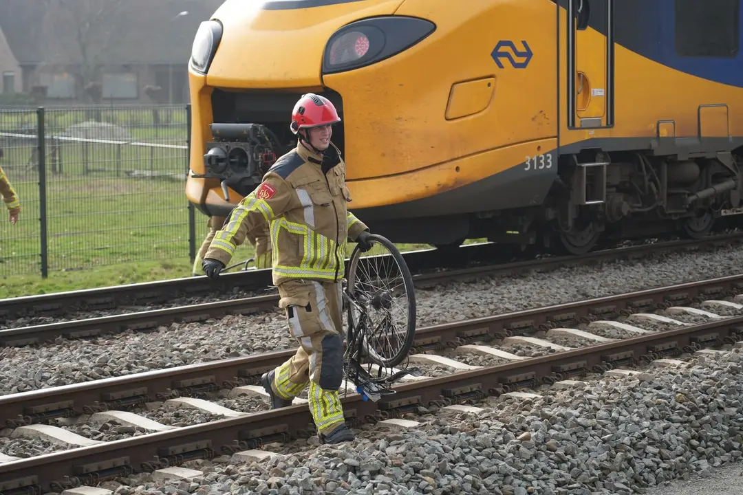 Fiets wordt voor trein gegooid.