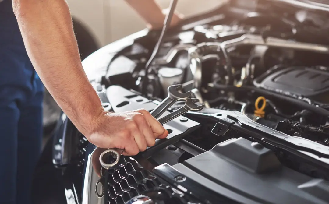 muscular car service worker repairing vehicle scaled