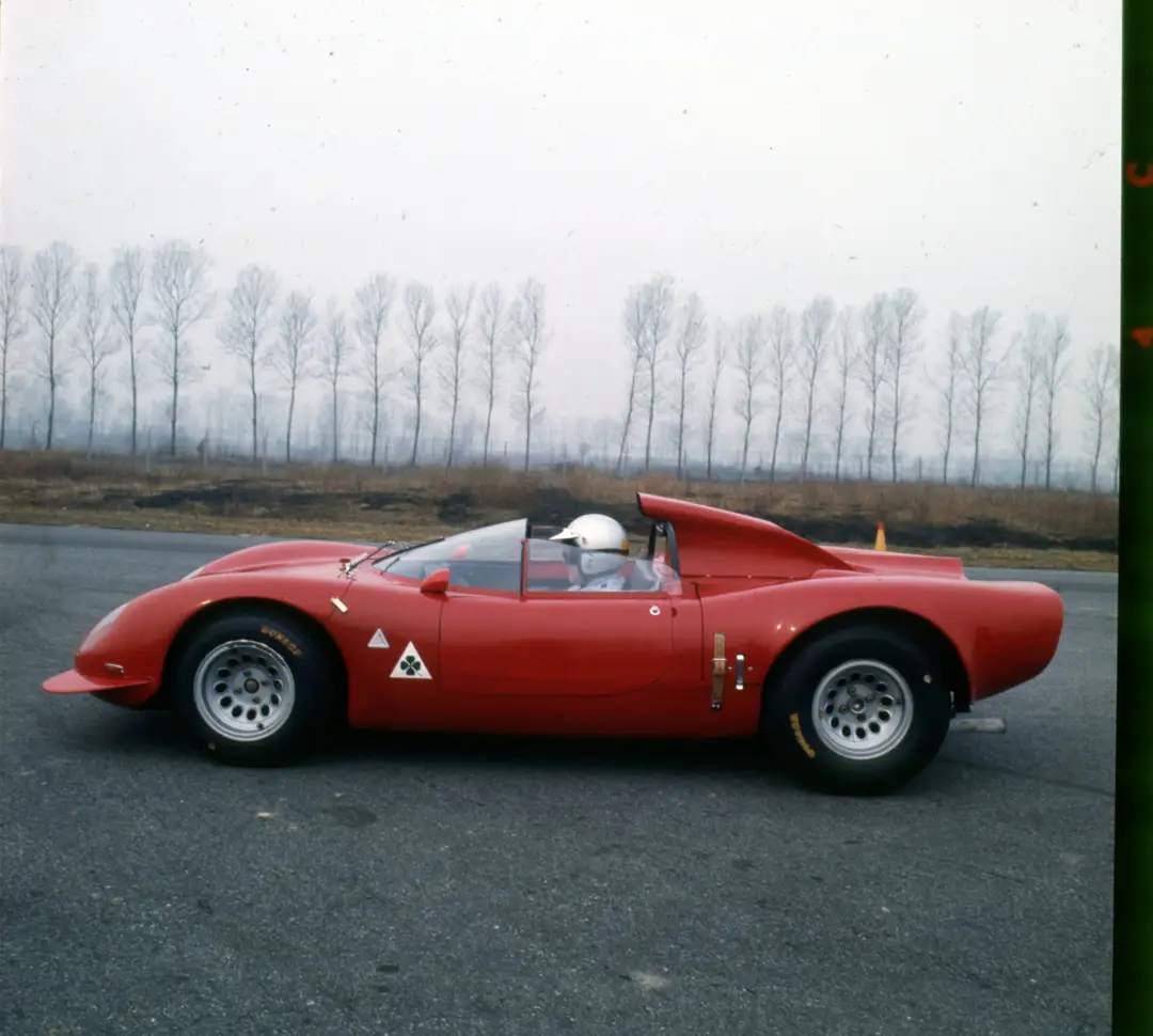 Immagine della Alfa Romeo 33/2 Periscopica di colore rosso su una strada con alberi sullo sfondo e nebbia