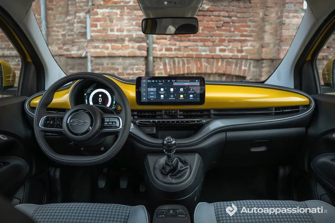 Interni della FIAT 500 Hybrid che mostra volante, cambio, plancia e i due schermi dell'infotainmente