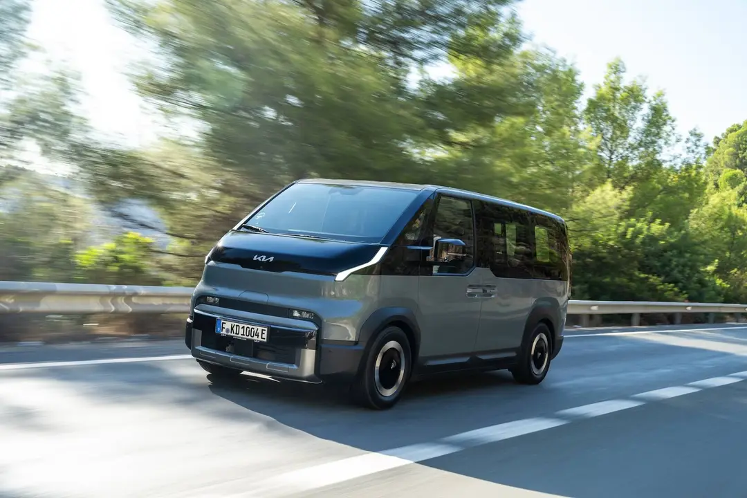 Una foto dinamica della Kia PV5 Passenger in verniciatura bicolore grigia e nera