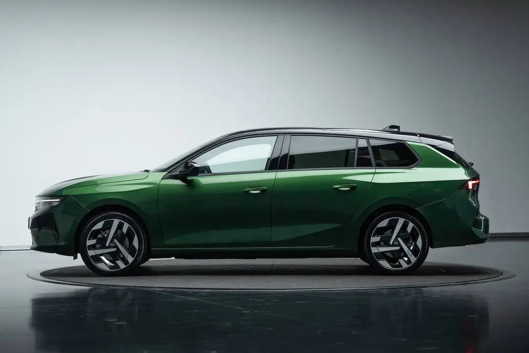 Vista laterale della Opel Astra 2026 Sports Tourer di colore verde con tetto nero e cerchi da 18 pollici dedicati all'allestimento GS