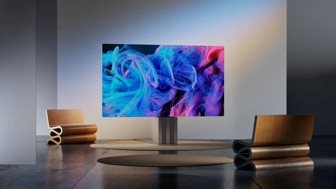 Render che mostra la televisione di Porsche all'interno di un salone di una casa, circondata da due sedie in legno