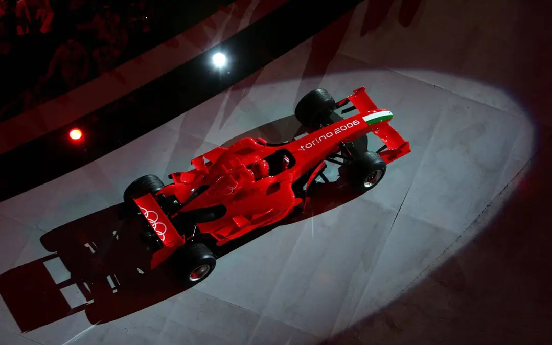 Luca Badoer sulla Ferrari F2005 esegue dei tondi tra il fumo delle gomme durante la cerimonia di apertura delle Olimpiadi invernali di Torino 2006, con i cerchi olimpici ben visibili sull'alettone posteriore