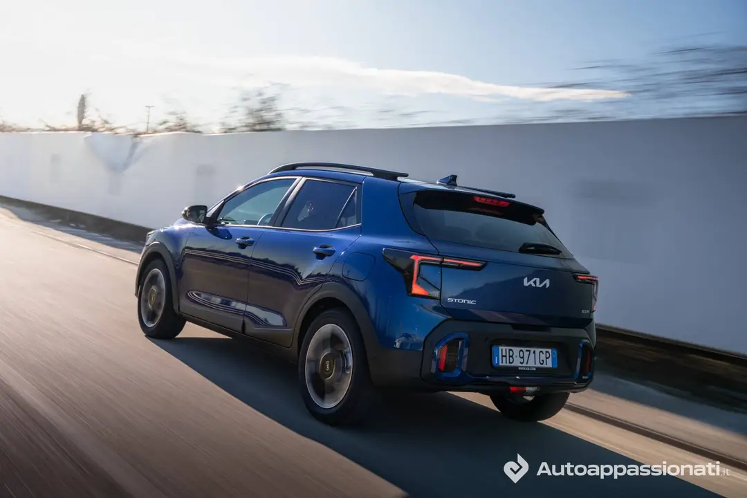 La Kia Stonic blu metallizzata ripresa dal posteriore mentre percorre una strada pubblica