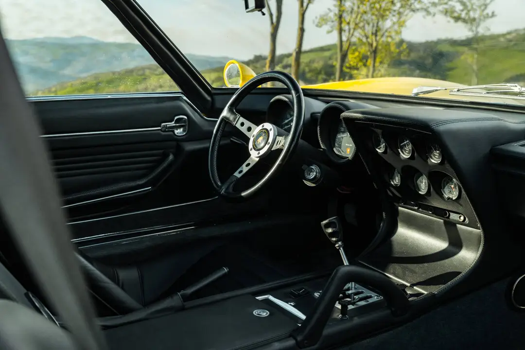 Esemplare di Lamborghini Miura SV ripreso dagli interni in pelle nera, si vedono volante una parte dei sedili e la strumentazione di bordo