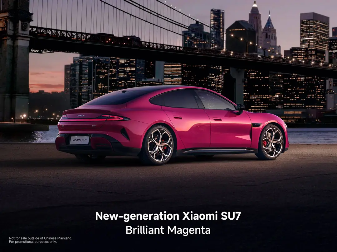 La Xiaomi SU7 di colore rosso al tramonto in posizione laterale posteriore