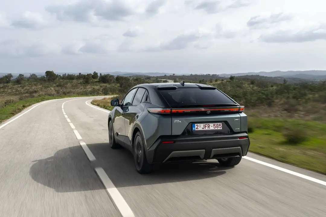 Il posteriore della Toyota C-HR+ 2026 impegnata in una curva di una strada statale tortuosa