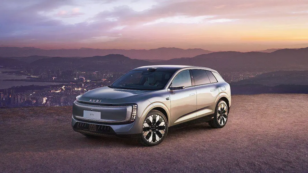 Nell'immagine si vede la Audi e7x e sullo sfondo un tramonto